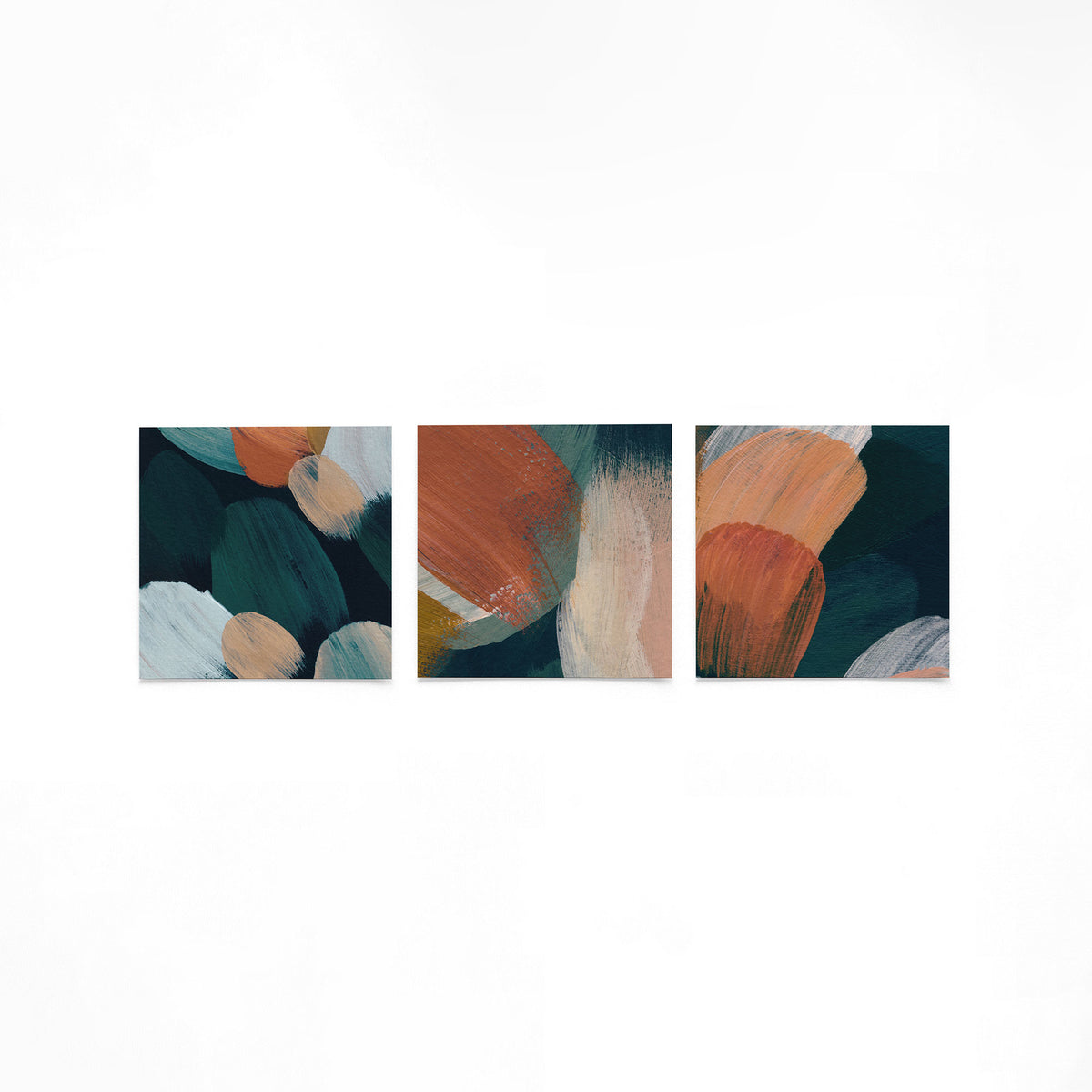 Drie vierkante posters met abstracte penseelstreken op een gebroken witte achtergrond