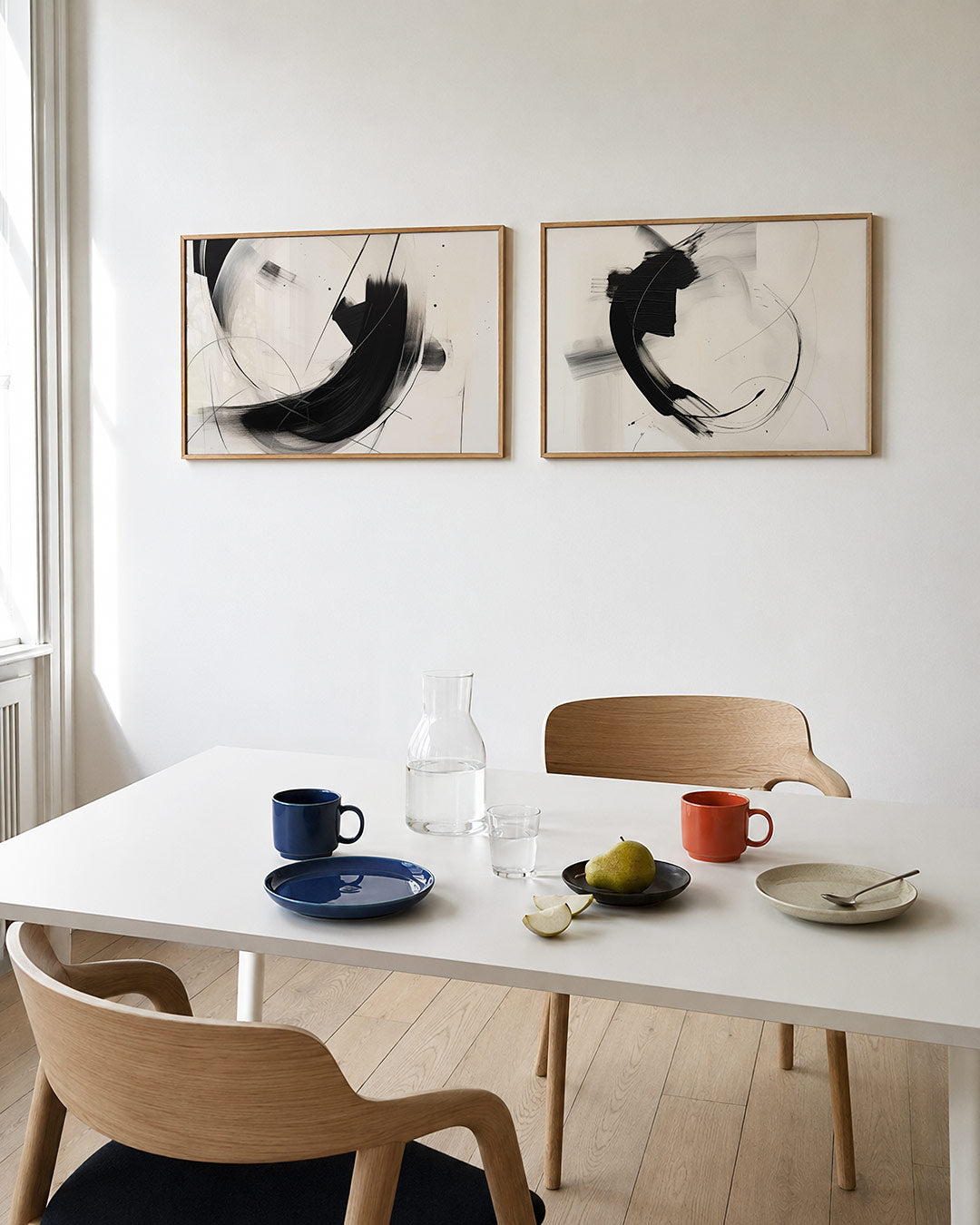 Twee liggende posters met vloeiende zwarte en grijze lijnen op een witte achtergrond, aan de muur in een interieur