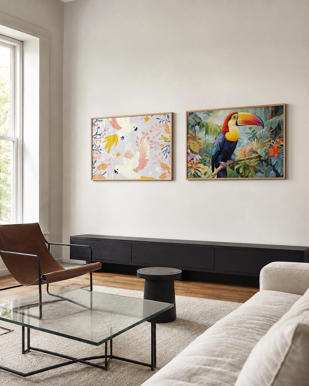 Twee liggende posters met witte vogels met gele staarten en roze vleugels tussen bladeren, aan de muur in een interieur