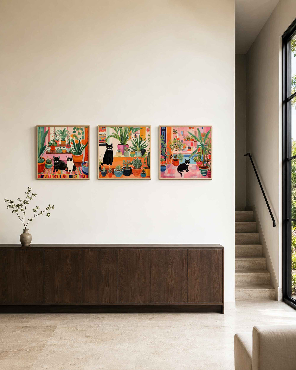 Interieurpresentatie van een driedelige vierkante posterset met katten tussen kamerplanten