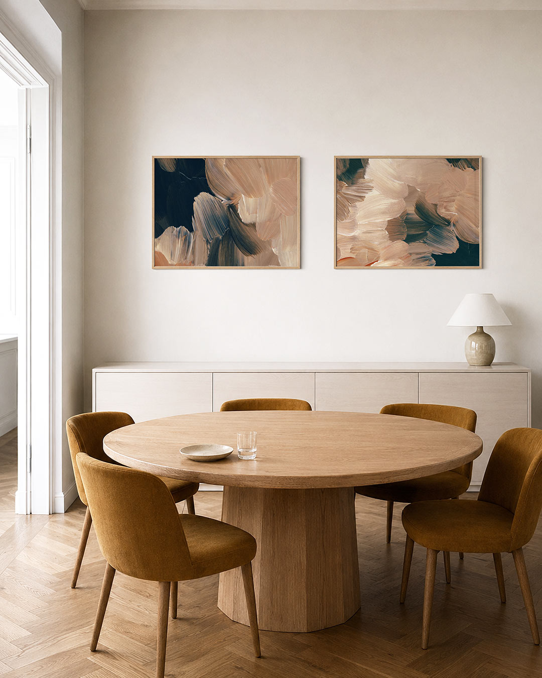 Twee liggende posters met vloeiende penseelstreken in warme beige en donkere tinten, aan de muur in een interieur