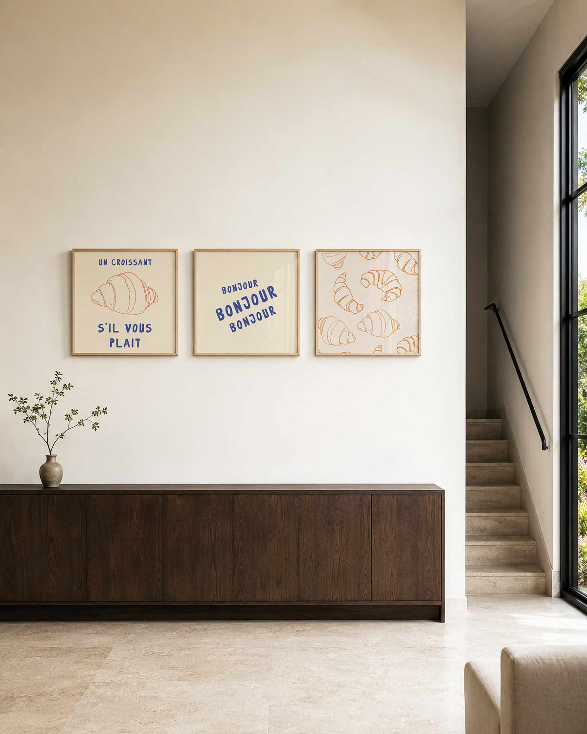 Interieurpresentatie van een driedelige vierkante posterset met croissant en bonjour