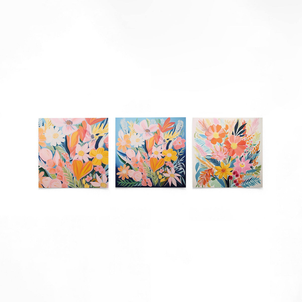 Drie vierkante posters met kleurrijke bloemen op een gebroken witte achtergrond
