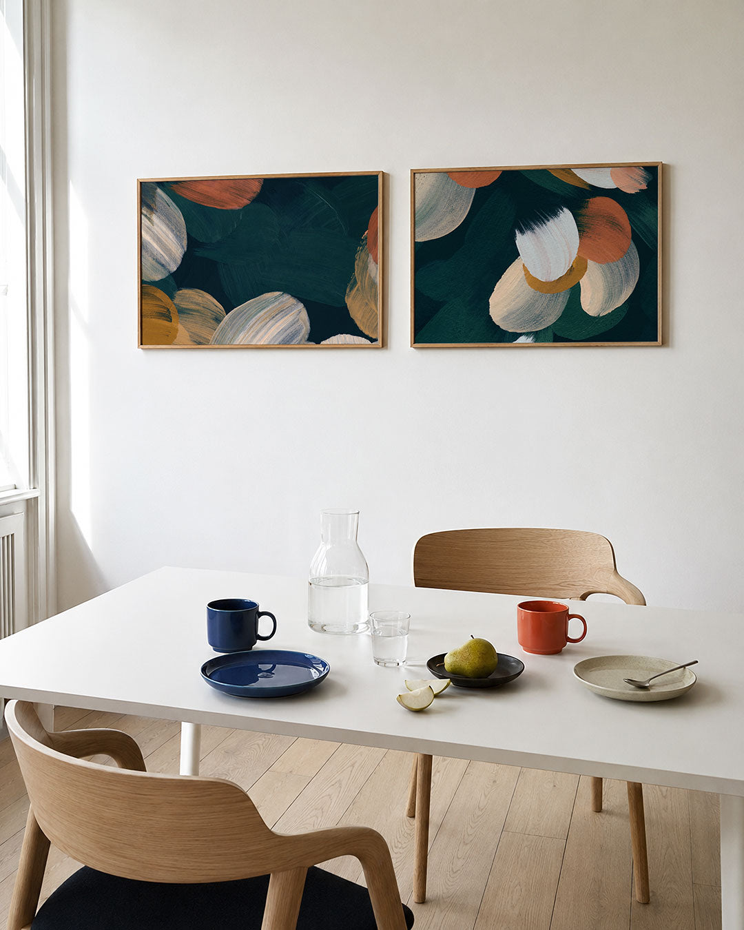 Tweedelige posterset met vloeiende penseelstreken in warme tinten, getoond in een interieur