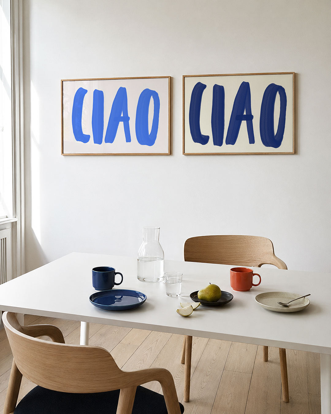 Interieurpresentatie van twee posters met grote, speelse blauwe letters op een lichte achtergrond
