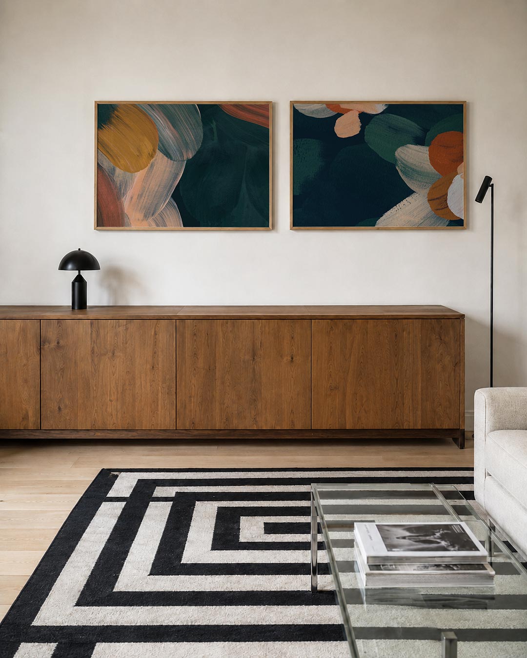 Twee liggende posters met vloeiende penseelstreken in warme tinten, aan de muur in een interieur