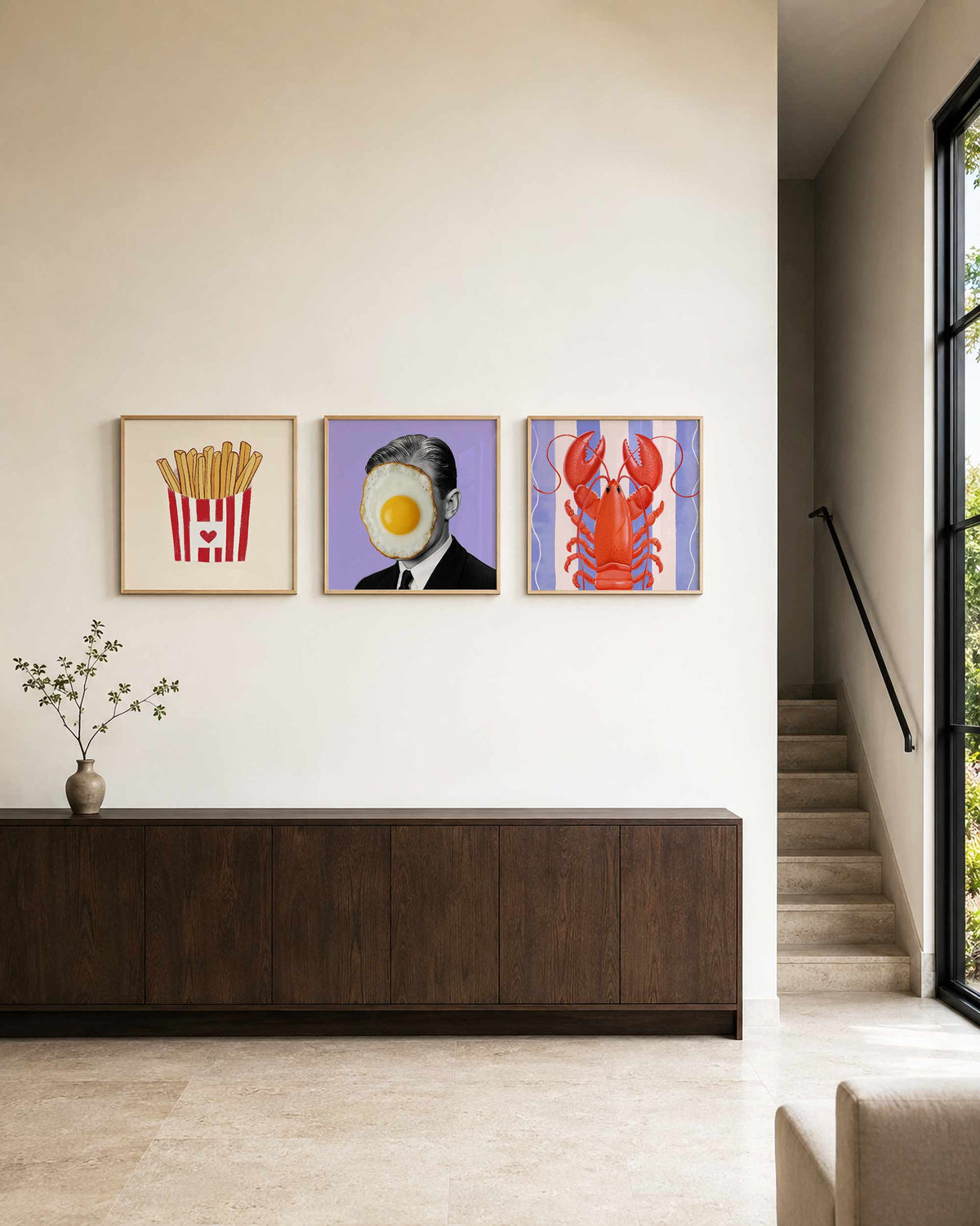 Interieurpresentatie van een driedelige vierkante posterset met friet ei en kreeft