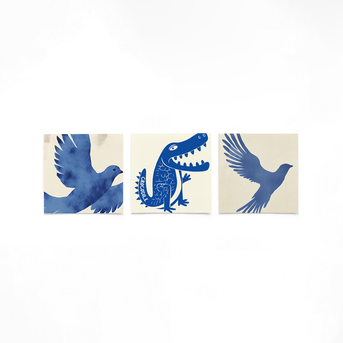 Drie vierkante posters met blauwe dieren op een gebroken witte achtergrond