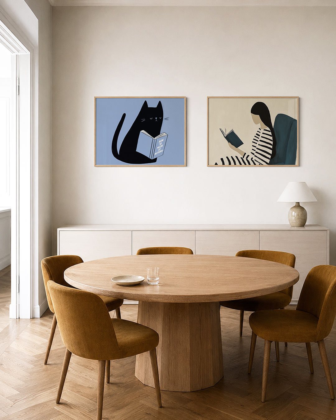 Tweedelige posterset met een zwarte kat met een boek op een zachte blauwe achtergrond, getoond in een interieur