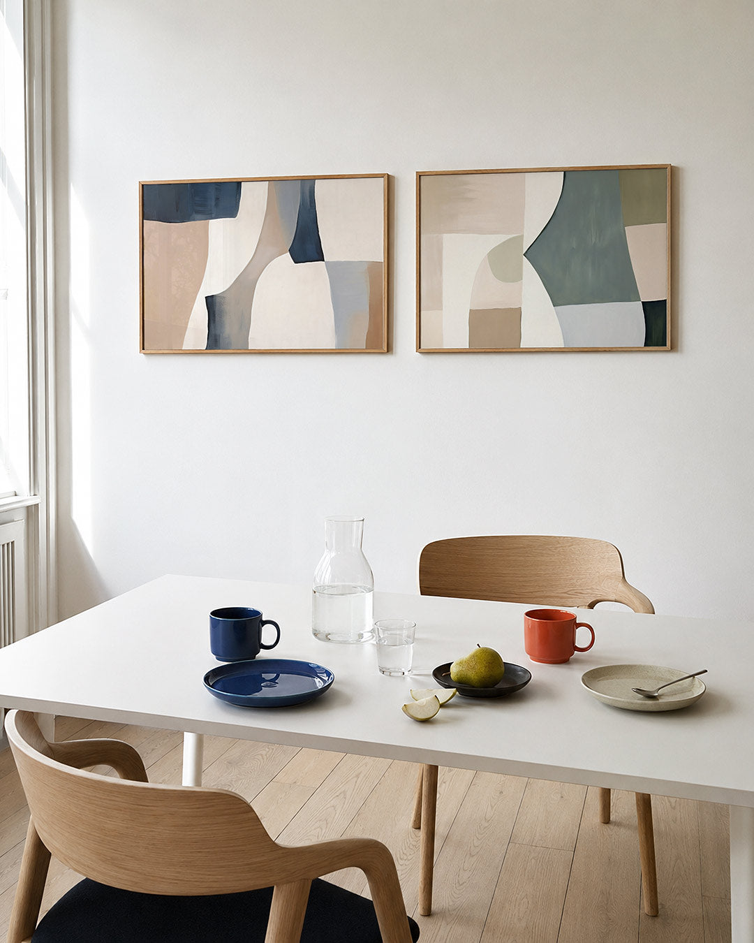 Tweedelige posterset met zachte, vloeiende vormen in beige, wit en blauwgrijs, getoond in een interieur