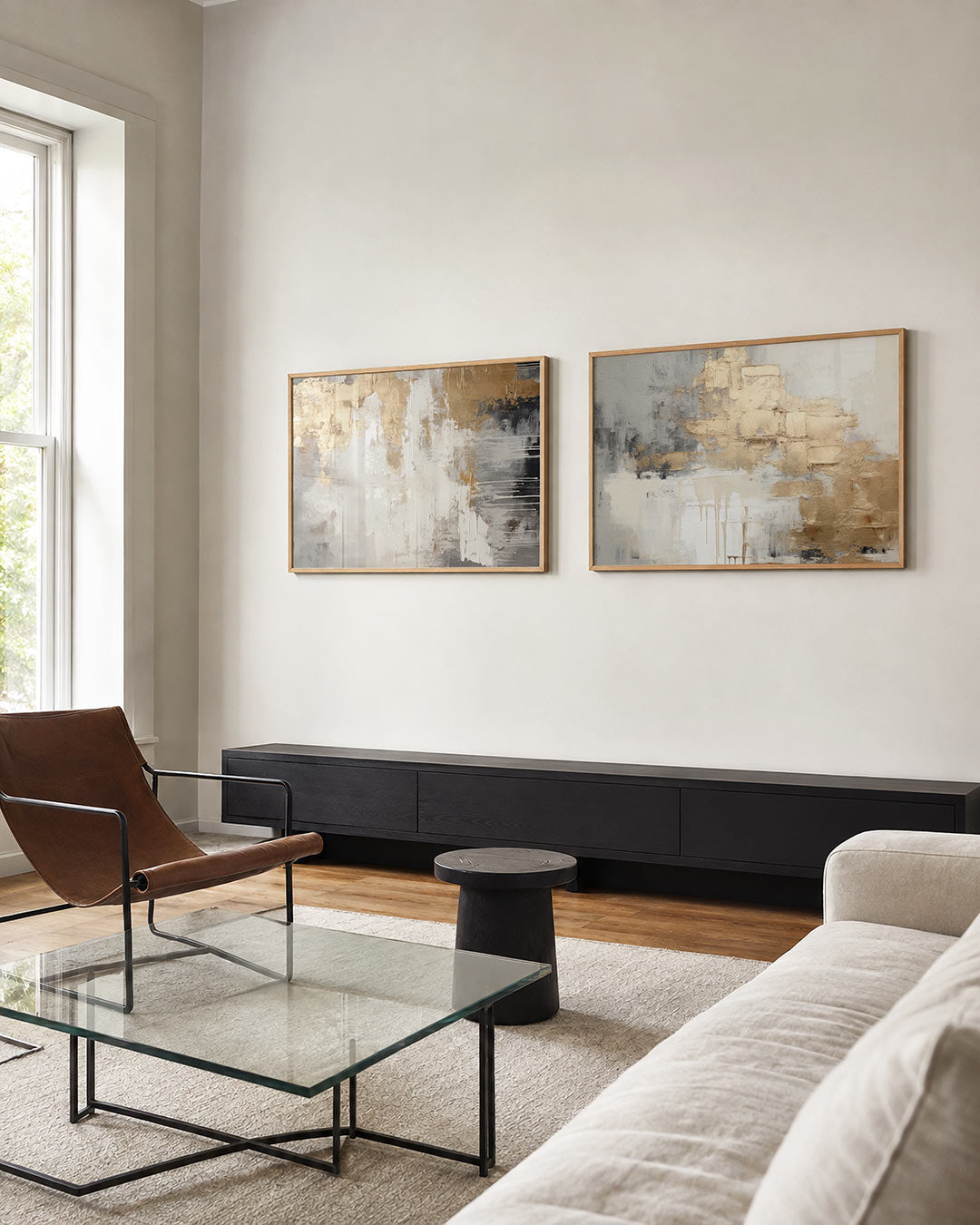 Tweedelige posterset met een spel van gouden en witte vegen op een grijze achtergrond, getoond in een interieur