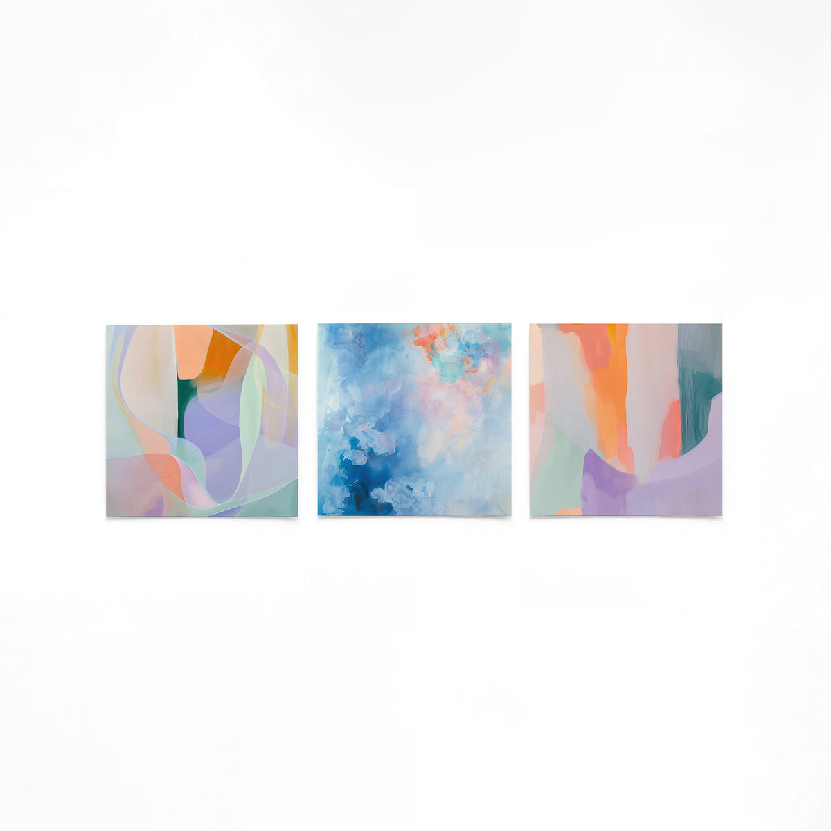 Drie vierkante posters met abstracte kleuren op een gebroken witte achtergrond