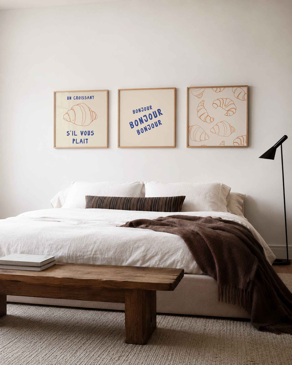 Interieurpresentatie van een driedelige vierkante posterset met croissant en bonjour