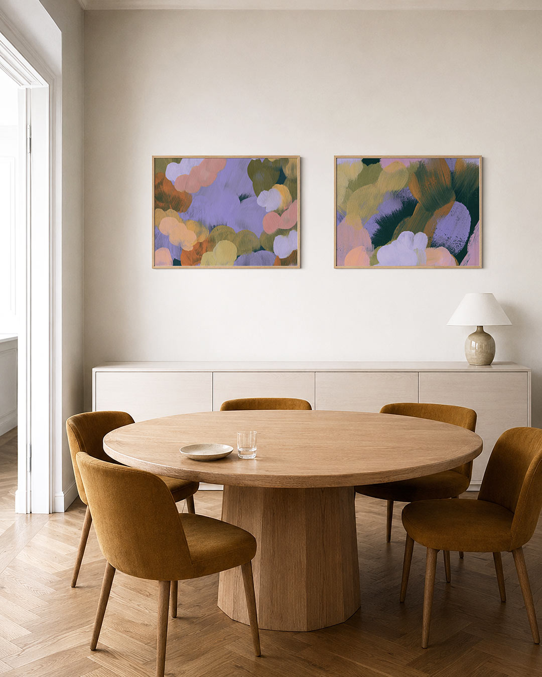 Twee liggende posters met ronde kleurvlakken in zachte tinten, aan de muur in een interieur