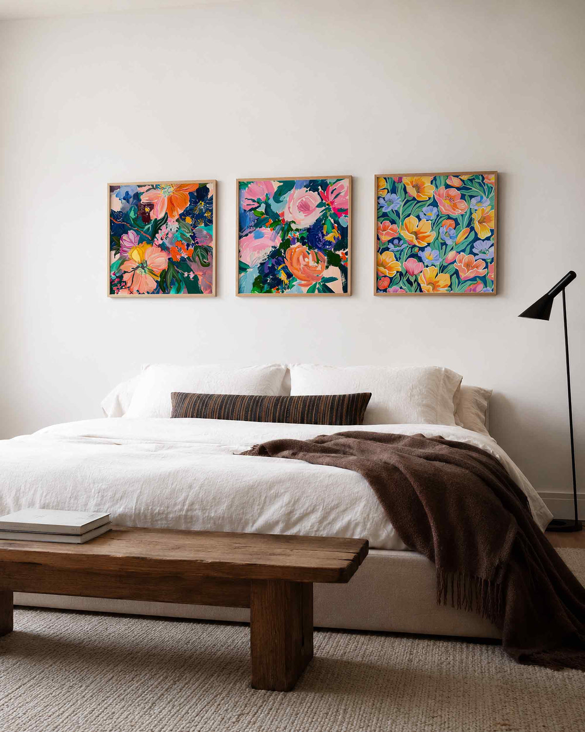 Interieurpresentatie van een driedelige vierkante posterset met kleurrijke bloemen