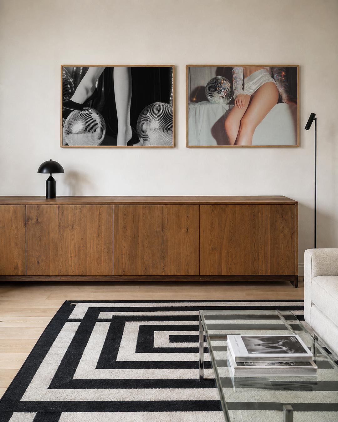 Twee liggende posters met benen in hoge hakken rustend op glanzende spiegelbollen, aan de muur in een interieur