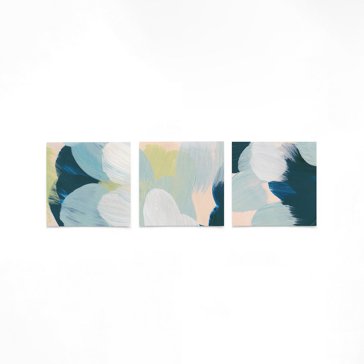 Drie vierkante posters met abstracte penseelstreken op een gebroken witte achtergrond